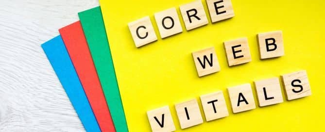 A imagem mostra papéis coloridos com quadrados de madeira com letras que formam as palavras "Core Web Vitals".
