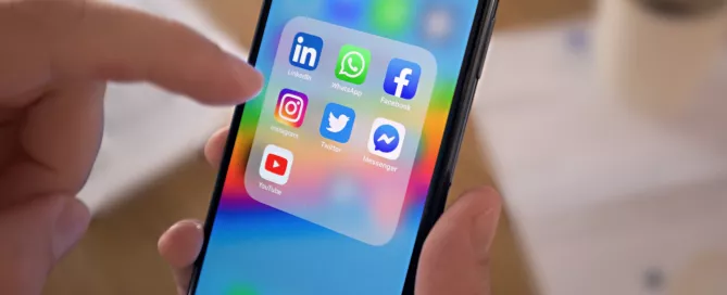 A foto foca na tela de um celular onde estão os ícones do LinkedIn, WhatsApp, Facebook, Instagram, Twitter, Messenger e Youtube.